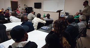 image of large group of students listening to instructor in classroom