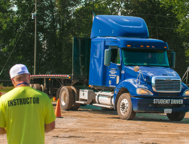 Image of blue CDL truck with instructor watching